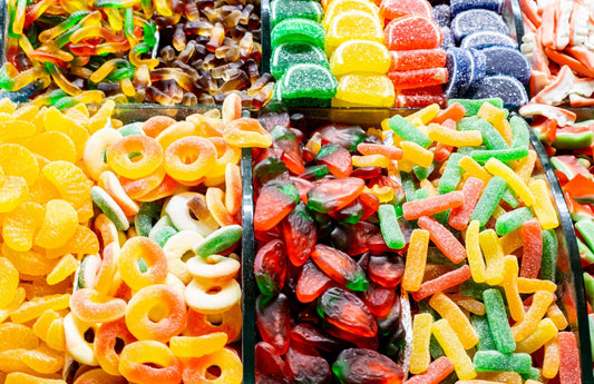 A close-up view of vibrant and colorful jelly candies in assorted shapes arranged invitingly at a market stall.