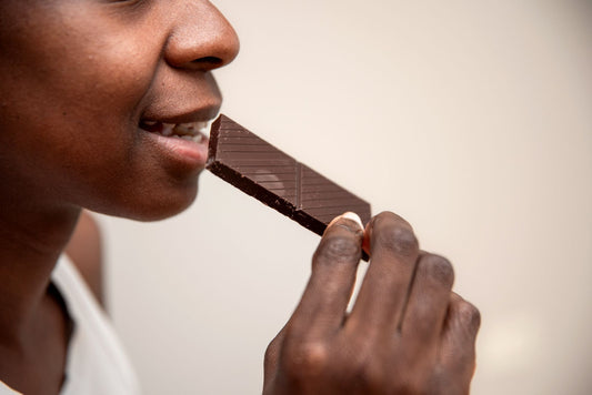 : Woman eating a bar of chocolate. 