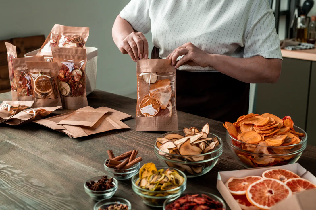 A woman packs freeze-dried oranges, kiwis, persimmons, pears, and strawberries from glass bowls.