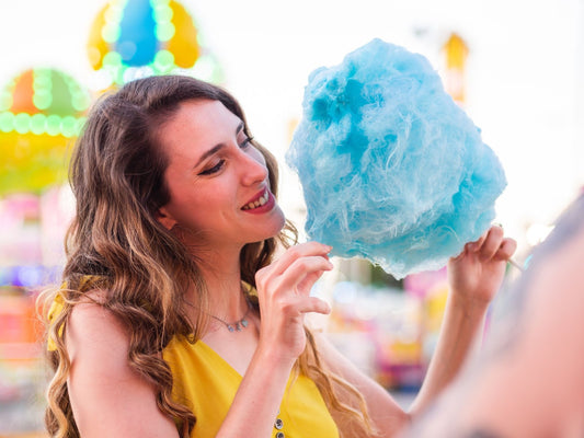  A woman marvels at the sight of her blue cotton candy in her hand.