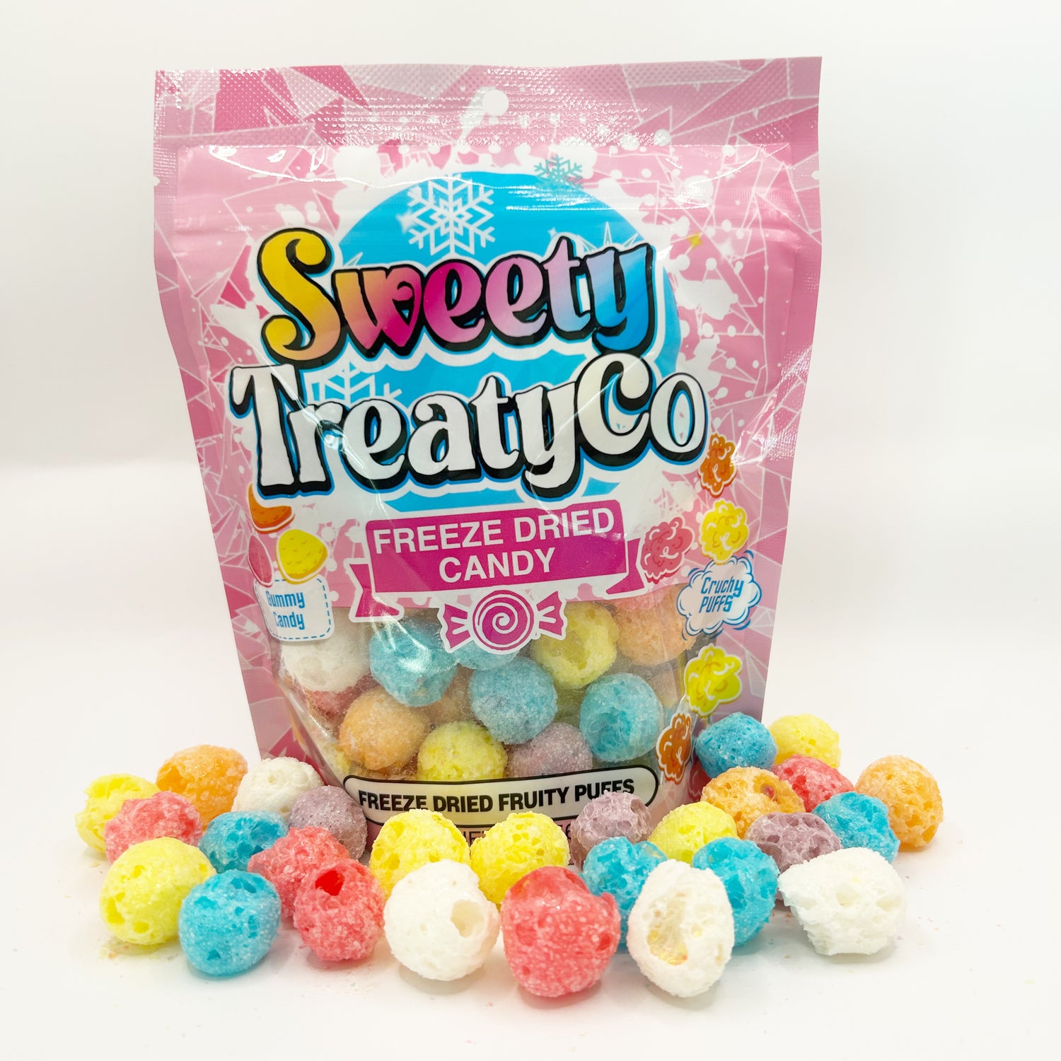 Colorful freeze-dried fruity puffs candy scattered in front of and around a vibrant pink bag.